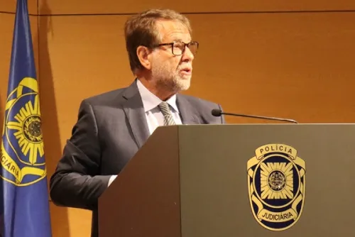 O diretor de PJ Portugal de Luís Neles fala durante a conferência de imprensa lançando o alarme extremo à direita. Uma bandeira e o logotipo della Policicia Judiciaria são visíveis.