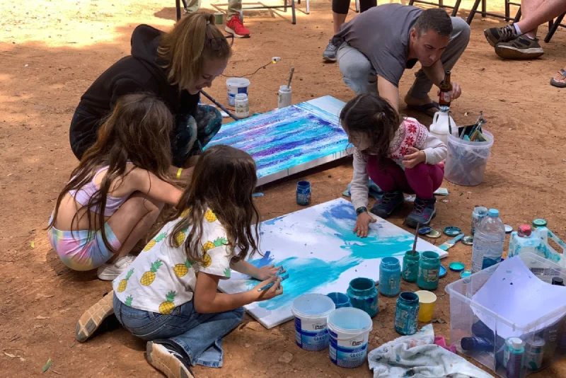 Algumas crianças no chão pintam uma obra de arte contemporânea da exposição The Magnificent Four.